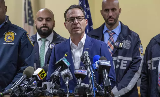 Gov. Josh Shapiro, center, speaks during a press conference regarding the arrest of suspect Luigi Mangione, Monday, Dec. 9, 2024, in Hollidaysburg, Pa., in the fatal shooting of UnitedHealthcare CEO Brian Thompson. (AP Photo/Ted Shaffrey)