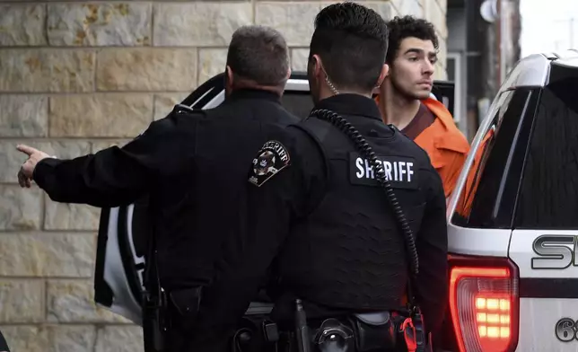 Luigi Nicholas Mangione is escorted into Blair County Courthouse, Tuesday, Dec. 10, 2024, in Hollidaysburg, Pa. (AP Photo/Gary M. Baranec)