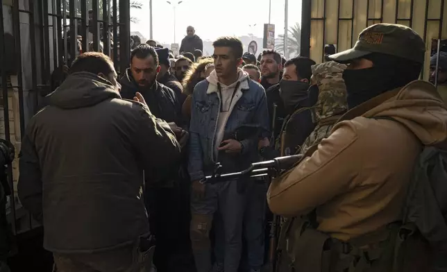 Members of Bashar Assad's army or a pro-government militia, gather to be registered with Syrian rebels as part of an "identification and reconciliation process" in Damascus, Syria, Saturday, Dec. 21, 2024. (AP Photo/Leo Correa)