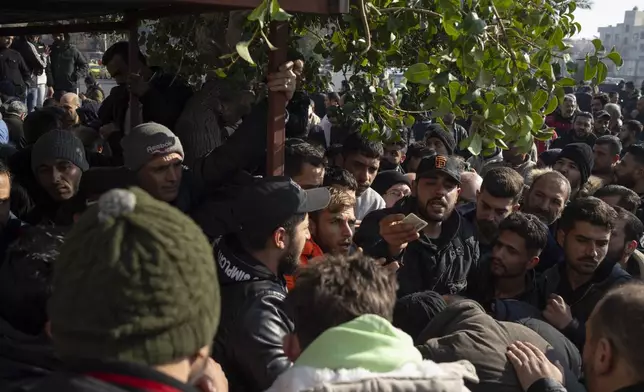 Members of Bashar Assad's army, or a pro-government militia, gather to be registered with Syrian rebels as part of an "identification and reconciliation process" in Damascus, Syria, Saturday, Dec. 21, 2024. (AP Photo/Leo Correa)