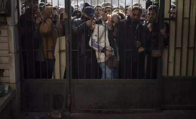 Members of Bashar Assad's army or a pro-government militia, gather to be registered with Syrian rebels as part of an "identification and reconciliation process" in Damascus, Syria, Saturday, Dec. 21, 2024. (AP Photo/Leo Correa)