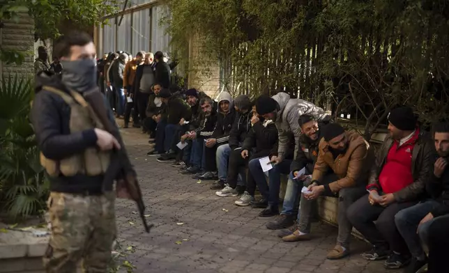 Members of Bashar Assad's army, or a pro-government militia, line up to register with Syrian rebels as part of an "identification and reconciliation process" in Damascus, Syria, Saturday, Dec. 21, 2024. (AP Photo/Leo Correa)