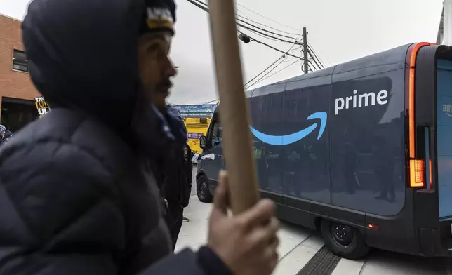 Amazon workers and members of the International Brotherhood of Teamsters picket in front of the Amazon fulfillment center in the Queens borough of New York, Friday, Dec. 20, 2024. (AP Photo/Stefan Jeremiah)