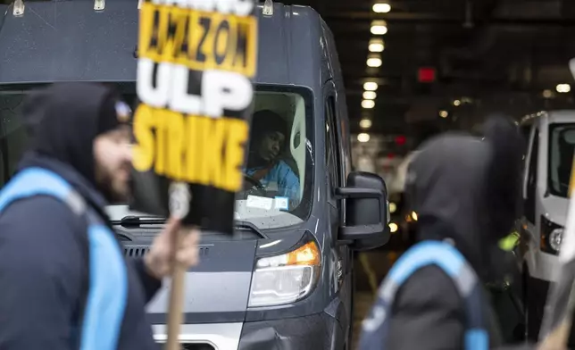 Amazon workers and members of the International Brotherhood of Teamsters picket in front of the Amazon fulfilment center in the Queens borough of in New York, on Friday, Dec. 20, 2024. (AP Photo/Stefan Jeremiah)