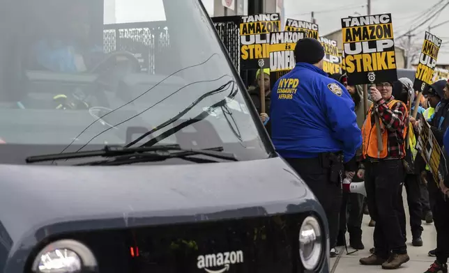 Amazon workers and members of the International Brotherhood of Teamsters picket in front of the Amazon fulfillment center in the Queens borough of New York, Friday, Dec. 20, 2024. (AP Photo/Stefan Jeremiah)