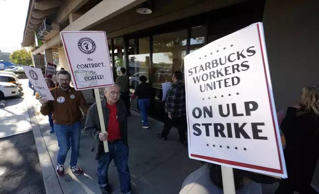 Starbuck workers picket outside of a closed Starbucks on Friday, Dec. 20, 2024, in Burbank, Calif. (AP Photo/Damian Dovarganes)