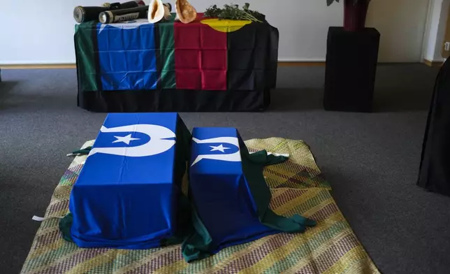 Two coffins lie on a traditional mat during a ceremony for the return of Aboriginal Australians' ancestors to their relatives and communities at the Ethnological Museum in Berlin, Germany, Thursday, Dec. 5, 2024. (AP Photo/Markus Schreiber)