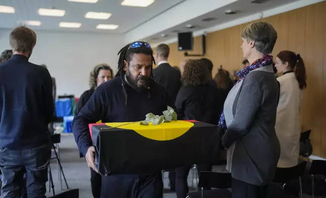 Yessie Mosby from Ugar Island in Australia carries a coffin, after a ceremony for the return of Aboriginal Australians ancestors to their relatives and communities at the Ethnological Museum in Berlin, Germany, Thursday, Dec. 5, 2024. (AP Photo/Markus Schreiber)