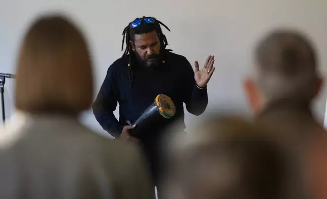 Yessie Mosby from Ugar Island in Australia claps on a drum during a ceremony for the return of Aboriginal Australians ancestors to their relatives and communities at the Ethnological Museum in Berlin, Germany, Thursday, Dec. 5, 2024. (AP Photo/Markus Schreiber)