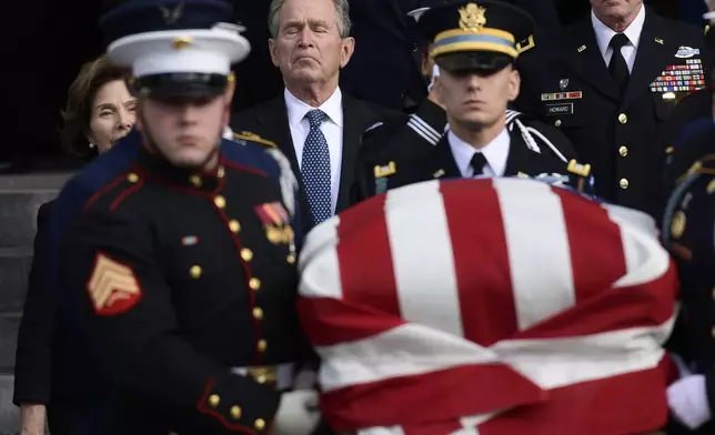 FILE - Former President George W. Bush and former first lady Laura Bush, left, follow the casket of former President George H.W. Bush, carried out following a State Funeral at the National Cathedral in Washington, Dec. 5, 2018. (AP Photo/Susan Walsh, File)