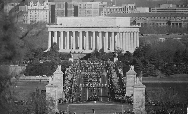 FILE - The funeral procession for the late President John Fitzgerald Kennedy, the nation's youngest president struck down by an assassin's bullets, crossed the bridge leading to Arlington National Cemetery in Arlington, Va., Nov. 25, 1963. The procession slowly moves over the Memorial Bridge, with Lincoln memorial in background, monument to another slain president. (AP Photo, File)