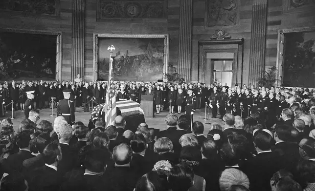 FILE - President Richard Nixon, center, speaks from a podium in front of the casket of Dwight D. Eisenhower in the Capitol Rotunda in Washington, March 30, 1969. From left, front: former first lady Mamie Eisenhower, the widow; son John Eisenhower and his wife, Barbara Eisenhower; first lady Pat Nixon and daughter Tricia. (AP Photo, File)