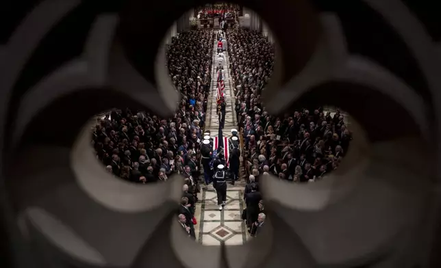 FILE - The flag-draped casket of former President George H.W. Bush is carried by a military honor guard into a State Funeral at the National Cathedral, Dec. 5, 2018, in Washington. (AP Photo/Andrew Harnik, Pool, File)