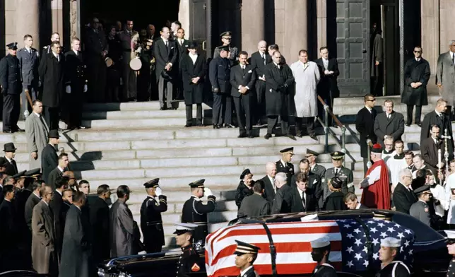 FILE - A general view outside St. Matthew's Cathedral in Washington, D.C., during President John F. Kennedy's funeral, with flag-draped coffin in the foreground, Nov. 25, 1963. The president's brothers can be seen behind the casket. At left is Sen. Edward M. Kennedy (D-Mass.), and at right entering limousine is Attorney General Robert F. Kennedy. (AP Photo, File)