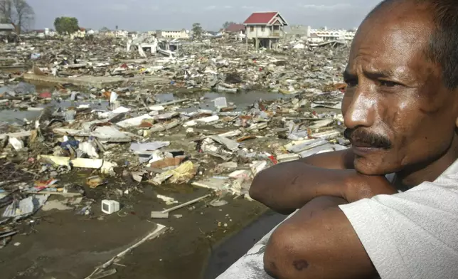 Jakfar, 41, looks at the destruction from the second floor of his house in Keudah village in the provincial capital of Banda Aceh, Aceh province, Indonesia, Monday, Feb. 7, 2005. (AP Photo/Dita Alangkara, File)