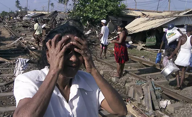 An unidentified woman cries after tidal waves destroyed her house on the coastal areas in Colombo, Sri Lanka, Sunday, Dec. 26, 2004. (AP Photo/Eranga Jayawardena, File)