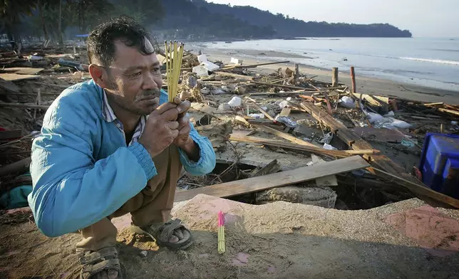 Kusol Wetchakul offers prayers for the soul of his sister Wednesday, Dec. 29, 2004, at dawn along the beach near Khao Lak, Thailand. Wetchakul's sister was swept out to sea and believed drowned as she sold goods to tourists on the popular tourist beach just north of Phuket. (AP Photo/David Longstreath, File)