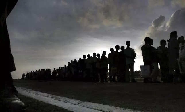 Tsunami victims wait for a airplane to be evacuated from Nicobar, in India's southeastern Andaman and Nicobar Islands, Wednesday, Dec. 29, 2004. (AP Photo/Manish Swarup, File)