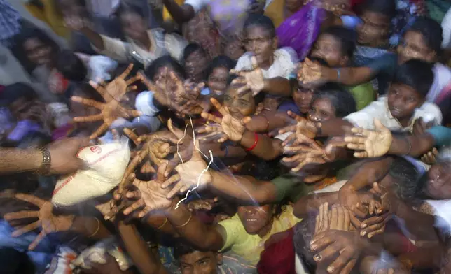 Tsunami victims at a relief camp reach for rice packets being distributed in Nagappattinam, in the southern Indian state of Tamil Nadu, Friday, Dec. 31, 2004. (AP Photo/Gurinder Osan, File)