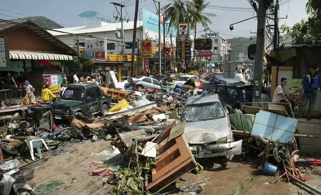 A street is littered with damaged vehicles and debris after the area was hit by tidal waves at Patong beach in Phuket, Thailand, Sunday December 26, 2004. (AP Photo/Karim Khamzin, File)