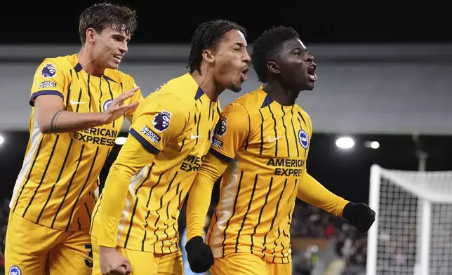 Brighton and Hove Albion's Carlos Baleba, right, celebrates after scoring his sides first goal during the English Premier League soccer match between FC Fulham and Brighton &amp; Hove Albion in London, England, Thursday, Dec. 5, 2024. ( John Walton/PA via AP)