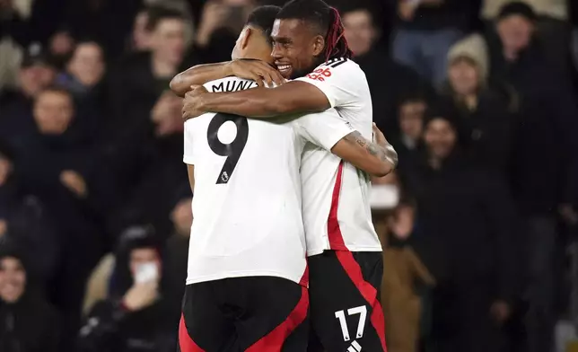 Fulham's Alex Iwobi, right, celebrates scoring the opening goal with Rodrigo Muniz during the Premier League match between Fulham and Brighton at Craven Cottage, London, Thursday Dec. 5, 2024. ( John Walton/PA via AP)