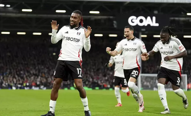 Fulham's Alex Iwobi, left, celebrates after scoring the opening goal during the English Premier League match between Fulham and Wolverhampton Wanderers at Craven Cottage stadium in London, Saturday, Nov. 23, 2024. (Zac Goodwin/PA via AP)