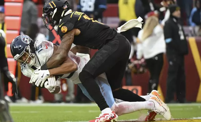 Tennessee Titans wide receiver Nick Westbrook-Ikhine (15) catches a touchdown pass in the end zone against the Washington Commanders safety Jeremy Chinn (11) during the second half of an NFL football game Sunday, Dec. 1, 2024, in Landover, Md. (AP Photo/Steve Ruark)