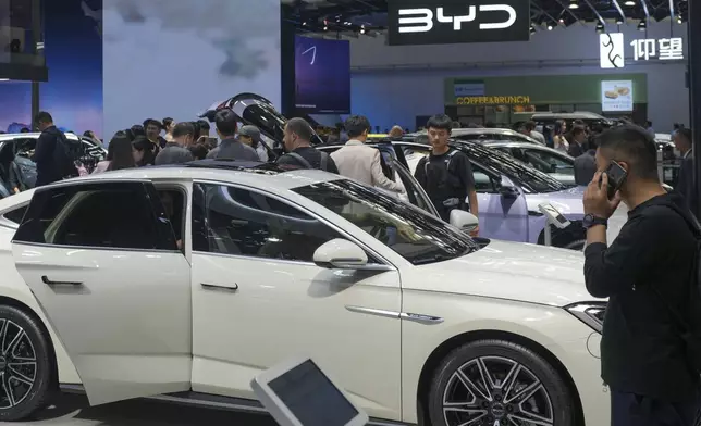 FILE - Visitors look at cars at the BYD booth during the China Auto Show in Beijing, China, April 26, 2024. (AP Photo/Tatan Syuflana, File)