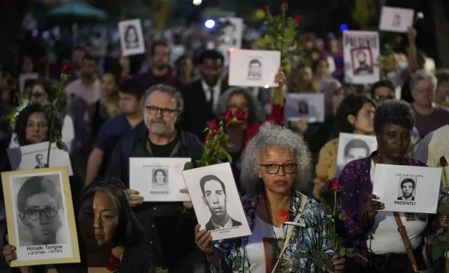 FILE - Demonstrators hold photos of people who were killed in Brazil's dictatorship, during the "Walk of Silence" march in memory of the victims, marking the anniversary of the country's 1964 coup, in Sao Paulo, April 2, 2023. (AP Photo/Andre Penner, File)