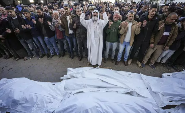 Palestinians pray over the bodies of the victims of an Israeli strike on a home late Saturday before the funeral outside the Al-Aqsa Martyrs Hospital in Deir al-Balah Sunday, Dec. 22, 2024. At least eight people were killed according to the hospital which received the bodies.(AP Photo/Abdel Kareem Hana)