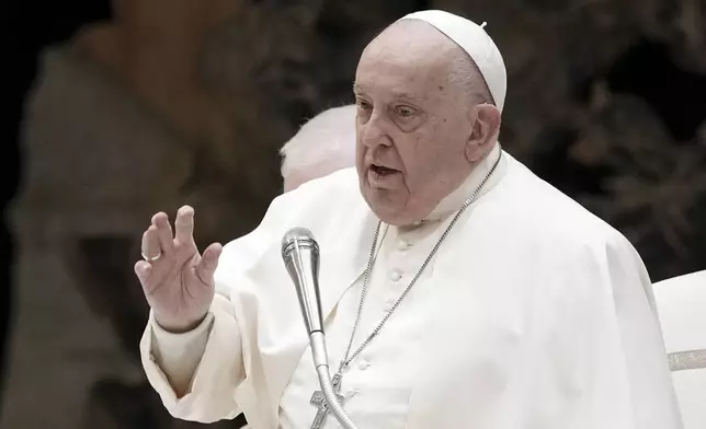 Pope Francis delivers his blessing as he exchanges season greetings with Vatican employees, in the Paul VI Hall at the Vatican, Saturday, Dec. 21, 2024. (AP Photo/Andrew Medichini)