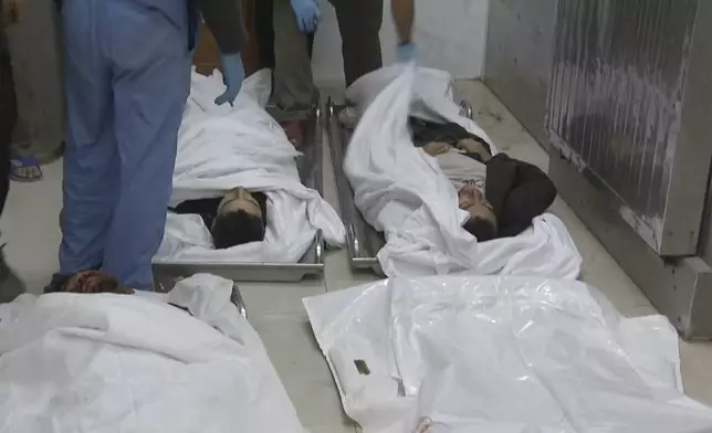 People stand near bodies on the ground inside the emergency department at Nasser hospital in Khan Younis after an Israeli airstrike on Saturday, Nov. 30, 2024. (AP Photo)