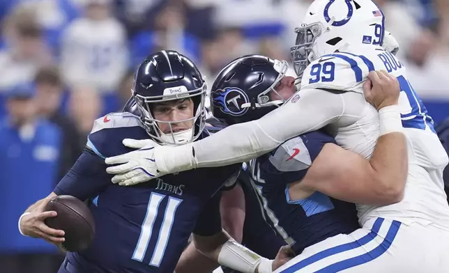 Indianapolis Colts defensive tackle DeForest Buckner (99) reaches past Tennessee Titans offensive lineman Daniel Brunskill, center, to pressure quarterback Mason Rudolph (11) during the first half of an NFL football game Sunday, Dec. 22, 2024, in Indianapolis. (AP Photo/Michael Conroy)