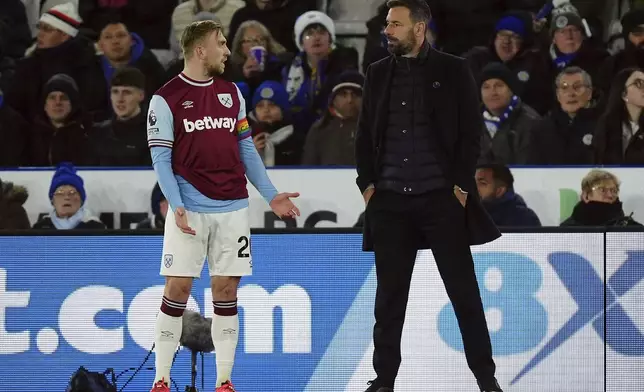 Leicester City manager Ruud van Nistelrooy, right, waits with West Ham United's Jarrod Bowen on a VAR check after Leicester City's Jamie Vardy scores their side's first goal of the game during a Premier League soccer match at the King Power Stadium, Tuesday Dec. 3, 2024, Leicester, England. (Mike Egerton/PA via AP)