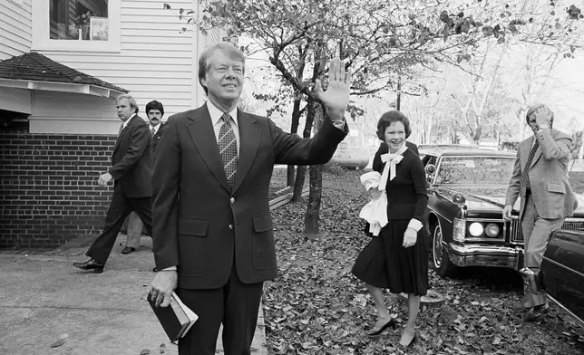 FILE - Then President-elect Jimmy Carter waves to the crowd as he and his wife Rosalynn arrive at the Plains Baptist Church to attend services in Plains, Ga., on Nov. 22, 1976. (AP Photo, File)