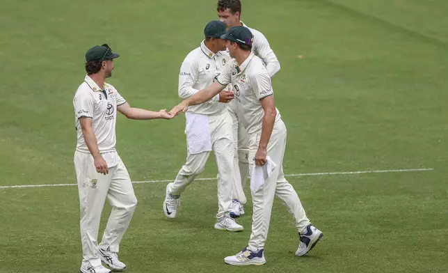 Australia's Travis Head, left, celebrates with teammates after the dismissal of India's Akash Deep during play on day five of the third cricket test between India and Australia at the Gabba in Brisbane, Australia, Wednesday, Dec. 18, 2024. (AP Photo/Pat Hoelscher)