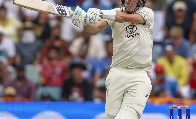 Australia's captain Pat Cummins hits a six during play on day five of the third cricket test between India and Australia at the Gabba in Brisbane, Australia, Wednesday, Dec. 18, 2024. (AP Photo/Pat Hoelscher)