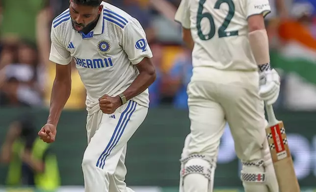 India's Mohammed Siraj, left, celebrates the wicket of Australia's Travis Head, right, during play on day five of the third cricket test between India and Australia at the Gabba in Brisbane, Australia, Wednesday, Dec. 18, 2024. (AP Photo/Pat Hoelscher)