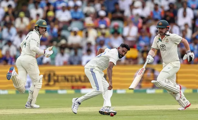 India's Mohammed Siraj, runs to field the ball as Australia's Travis Head, right, and Alex Carey, left, run between the wickets to score during play on day five of the third cricket test between India and Australia at the Gabba in Brisbane, Australia, Wednesday, Dec. 18, 2024. (AP Photo/Pat Hoelscher)