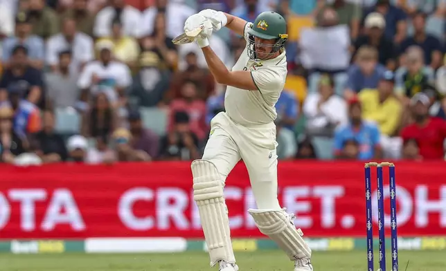 Australia's Mitchell Starc plays a shot during play on day five of the third cricket test between India and Australia at the Gabba in Brisbane, Australia, Wednesday, Dec. 18, 2024. (AP Photo/Pat Hoelscher)