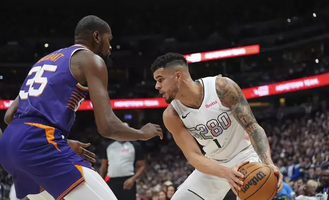 Denver Nuggets forward Michael Porter Jr., right, looks to pass the ball as Phoenix Suns forward Kevin Durant (35) covers in the first half of an NBA basketball game Monday, Dec. 23, 2024, in Denver. (AP Photo/David Zalubowski)