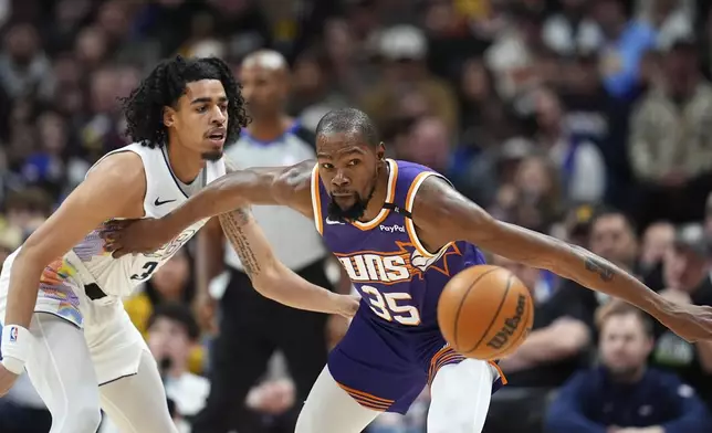 Phoenix Suns forward Kevin Durant, right, pursues the ball with Denver Nuggets guard Julian Strawther in the first half of an NBA basketball game Monday, Dec. 23, 2024, in Denver. (AP Photo/David Zalubowski)