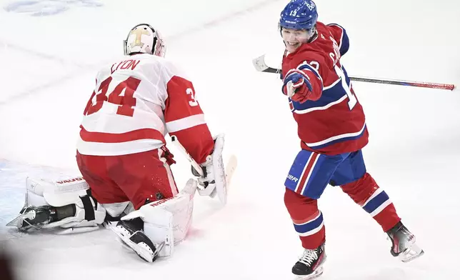 Montreal Canadiens' Cole Caufield (13) reacts to a goal by teammate Patrik Laine, not shown, against Detroit Red Wings goaltender Alex Lyon (34) during the first period of an NHL hockey game in Montreal, Saturday, Dec. 21, 2024. (Graham Hughes/The Canadian Press via AP)