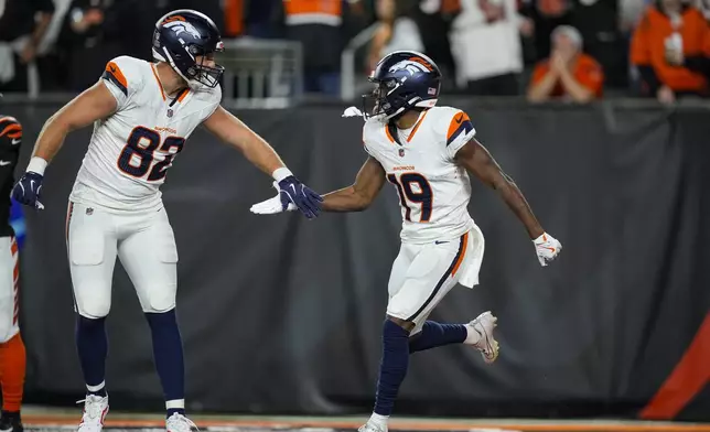 Denver Broncos wide receiver Marvin Mims Jr. (19) celebrates a touchdown with tight end Adam Trautman (82) against the Cincinnati Bengals during the second half of an NFL football game in Cincinnati, Saturday, Dec. 28, 2024. (AP Photo/Carolyn Kaster)