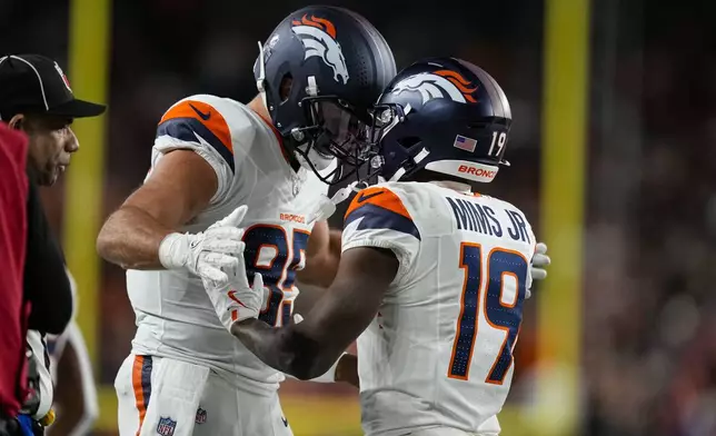 Denver Broncos wide receiver Marvin Mims Jr. (19) celebrates a touchdown with Denver Broncos tight end Lucas Krull (85) against the Cincinnati Bengals during the second half of an NFL football game in Cincinnati, Saturday, Dec. 28, 2024. (AP Photo/Carolyn Kaster)