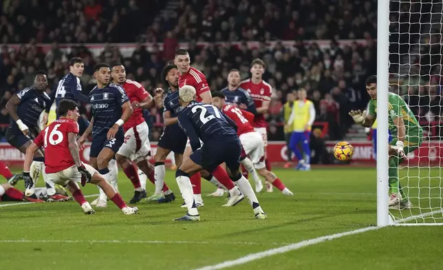 Aston Villa goalkeeper Emiliano Martinez, right, makes a save against Nottingham Forest's Nicolas Dominguez (16) during a Premier League soccer match at the City Ground, Saturday Dec 14, 2024, in Nottingham, England. (Joe Giddens/PA via AP)