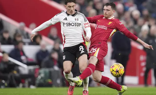 Liverpool's Andrew Robertson, right, duels for the ball with Fulham's Harry Wilson during the English Premier League soccer match between Liverpool and Fulham, at Anfield stadium in Liverpool, England, Saturday, Dec. 14, 2024. (AP Photo/Jon Super)