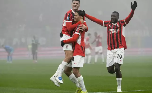 AC Milan's Tijjani Reijnders celebrates with Alvaro Morata, top left, and Youssouf Fofana after scoring his side's third goal during the Italian Serie A soccer match between AC Milan and Empoli, at the Milan San Siro stadium, Italy, Saturday, Nov. 30, 2024. (AP Photo/Luca Bruno)