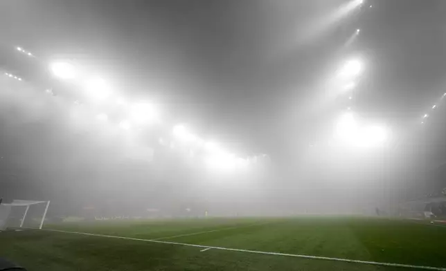 A thick fog shrouds the pitch during the Italian Serie A soccer match between AC Milan and Empoli, at the Milan San Siro stadium, Italy, Saturday, Nov. 30, 2024. (AP Photo/Luca Bruno)